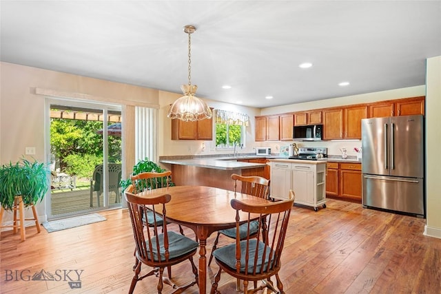 944 Forest Glen Dr, Bozeman, MT 59718 - kitchen featuring appliances with stainless steel finishes, a chandelier, light wood-style flooring, pendant lighting, and light countertops