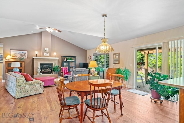 944 Forest Glen Dr, Bozeman, MT 59718 - dining area with light wood finished floors, vaulted ceiling, ceiling fan, and a glass covered fireplace