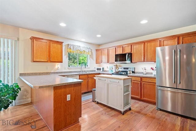 944 Forest Glen Dr, Bozeman, MT 59718 - kitchen featuring appliances with stainless steel finishes, a peninsula, light countertops, light wood-style flooring, and recessed lighting