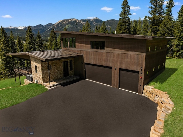 544 Grey Drake, Big Sky, MT 59716 - view of front of home featuring a mountain view, a front yard, a metal roof, driveway, and a standing seam roof