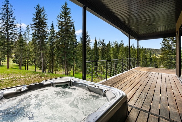 544 Grey Drake, Big Sky, MT 59716 - wooden deck with a hot tub and a view of trees