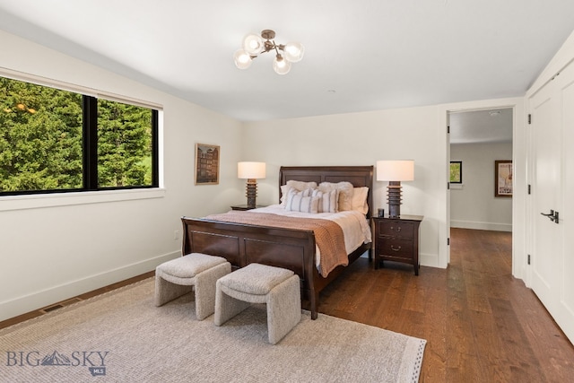 544 Grey Drake, Big Sky, MT 59716 - bedroom featuring dark wood-type flooring and a chandelier