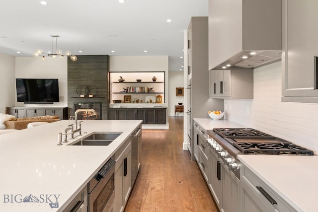 544 Grey Drake, Big Sky, MT 59716 - kitchen with wall chimney exhaust hood, stainless steel appliances, light countertops, recessed lighting, and wood finished floors