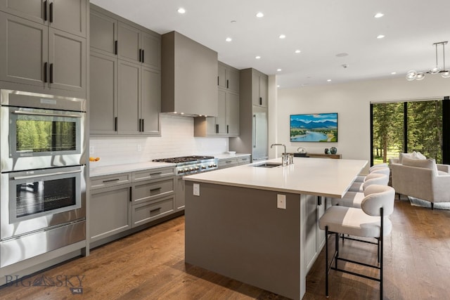 544 Grey Drake, Big Sky, MT 59716 - kitchen with stainless steel appliances, gray cabinets, a warming drawer, recessed lighting, and wall chimney range hood