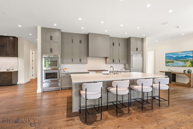 544 Grey Drake, Big Sky, MT 59716 - kitchen featuring gray cabinets, premium range hood, decorative backsplash, a spacious island, and recessed lighting