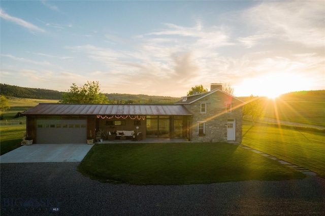 802 Deadmans Canyon Rd, Reed Point, MT 59069 - view of front facade with driveway, stone siding, a garage, a front lawn, and a standing seam roof