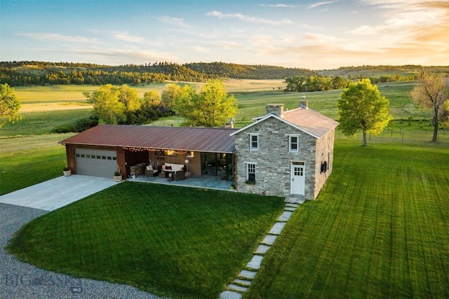 802 Deadmans Canyon Rd, Reed Point, MT 59069 - view of front of home featuring stone siding, driveway, a front yard, and a garage