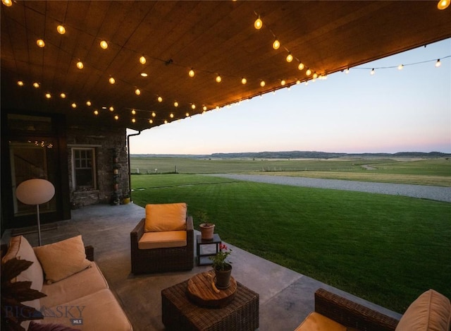 802 Deadmans Canyon Rd, Reed Point, MT 59069 - patio terrace at dusk with a patio area, an outdoor hangout area, a yard, and a view of countryside