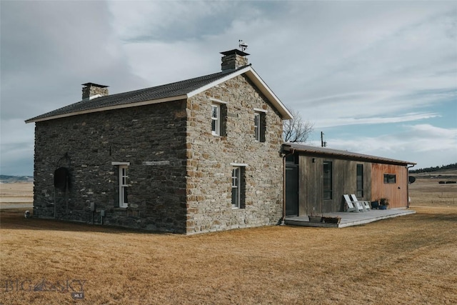 802 Deadmans Canyon Rd, Reed Point, MT 59069 - rear view of property with a chimney, stone siding, and a lawn
