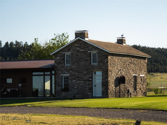 802 Deadmans Canyon Rd, Reed Point, MT 59069 - rear view of house with stone siding, a lawn, and a chimney