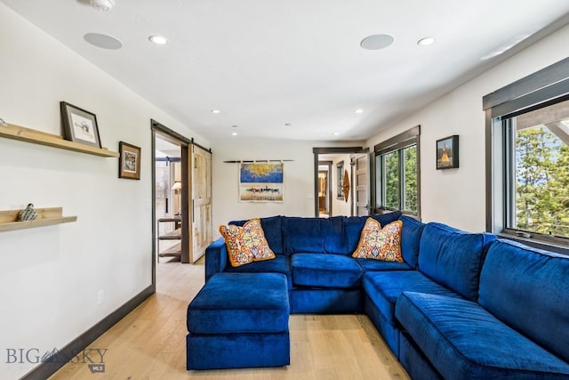 146 Outlook Trl, Big Sky, MT 59716 - living room with a barn door, recessed lighting, and light wood-style flooring