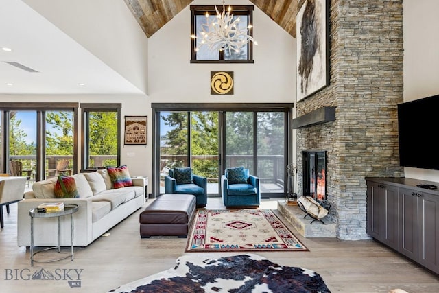 146 Outlook Trl, Big Sky, MT 59716 - living area with high vaulted ceiling, light wood-type flooring, plenty of natural light, a fireplace, and wooden ceiling
