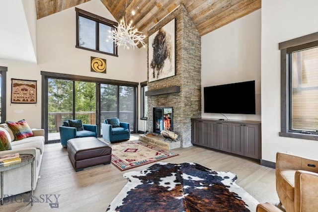 146 Outlook Trl, Big Sky, MT 59716 - living area featuring high vaulted ceiling, light wood finished floors, a fireplace, a chandelier, and wood ceiling