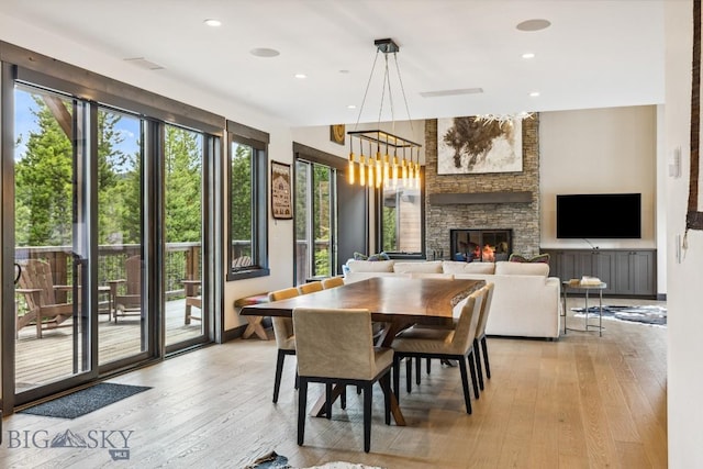 146 Outlook Trl, Big Sky, MT 59716 - dining room featuring light wood-type flooring, a fireplace, recessed lighting, and a chandelier
