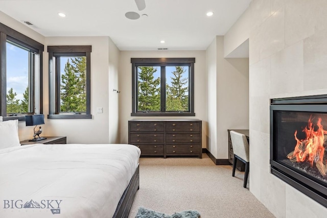 146 Outlook Trl, Big Sky, MT 59716 - bedroom featuring a fireplace, multiple windows, light carpet, and recessed lighting