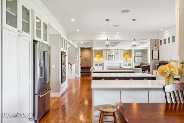33 Oasis Trl, Bozeman, MT 59718 - kitchen with stainless steel appliances, light wood-style flooring, crown molding, white cabinets, and a center island