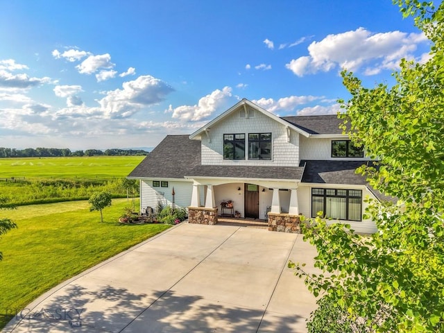 33 Oasis Trl, Bozeman, MT 59718 - view of front facade featuring a front lawn, roof with shingles, covered porch, and concrete driveway
