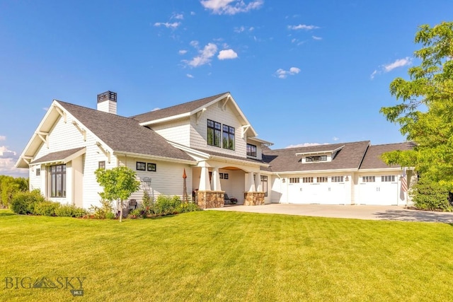 33 Oasis Trl, Bozeman, MT 59718 - view of front of house featuring a front yard, concrete driveway, a chimney, a shingled roof, and covered porch