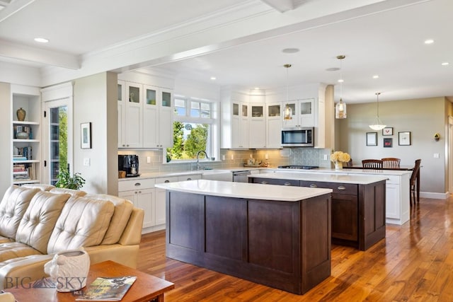 33 Oasis Trl, Bozeman, MT 59718 - kitchen with stainless steel appliances, a kitchen island, light countertops, open floor plan, and recessed lighting