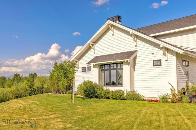 33 Oasis Trl, Bozeman, MT 59718 - rear view of house featuring a yard, a chimney, and a shingled roof