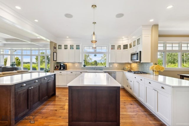 33 Oasis Trl, Bozeman, MT 59718 - kitchen featuring a kitchen island, appliances with stainless steel finishes, light countertops, recessed lighting, and crown molding