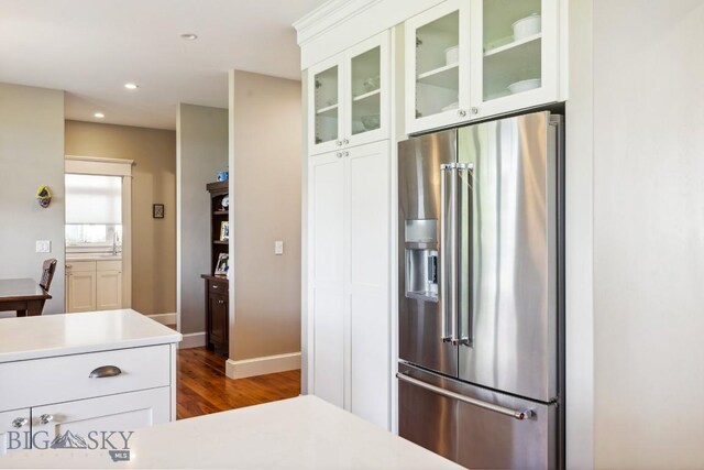 33 Oasis Trl, Bozeman, MT 59718 - kitchen with high end refrigerator, dark wood finished floors, glass insert cabinets, light countertops, and white cabinets
