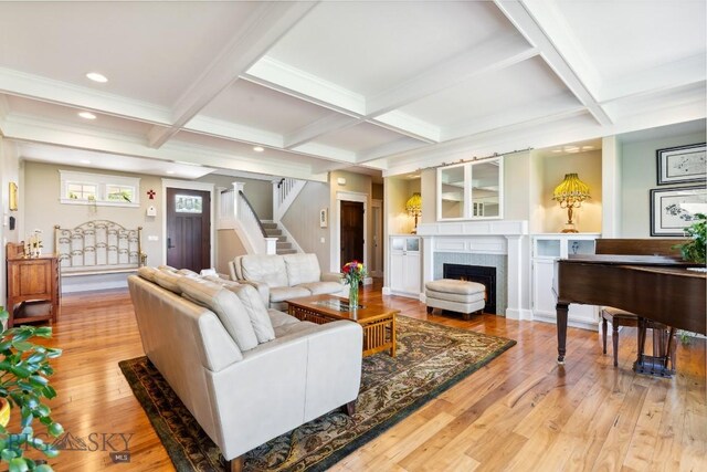 33 Oasis Trl, Bozeman, MT 59718 - living room with stairway, a lit fireplace, light wood finished floors, beam ceiling, and coffered ceiling
