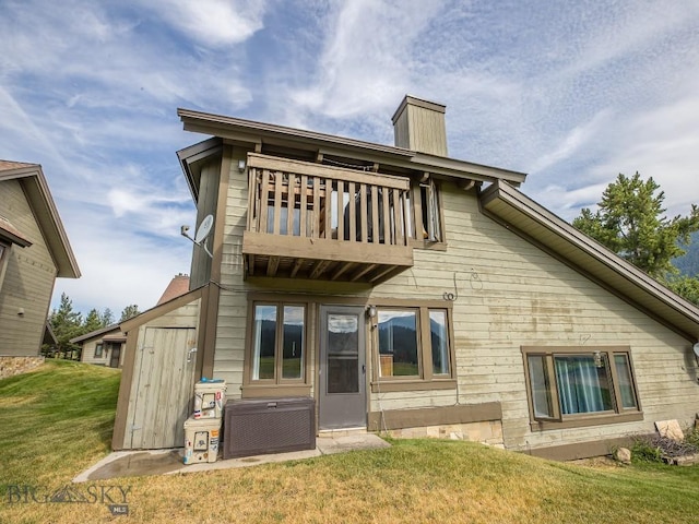 20 Yellowstone Spur Rd Unit 20A, Big Sky, MT 59716 - back of property with a balcony, a yard, and a chimney