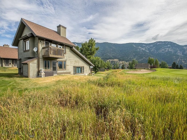 20 Yellowstone Spur Rd Unit 20A, Big Sky, MT 59716 - back of house with a balcony, a chimney, a mountain view, and a storage unit