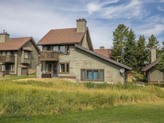 20 Yellowstone Spur Rd Unit 20A, Big Sky, MT 59716 - back of house with a chimney, a balcony, and a shingled roof