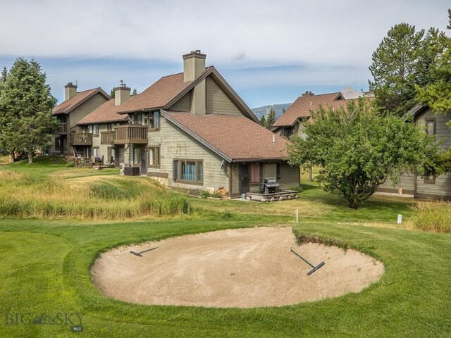20 Yellowstone Spur Rd Unit 20A, Big Sky, MT 59716 - back of property featuring a balcony, a yard, and a chimney
