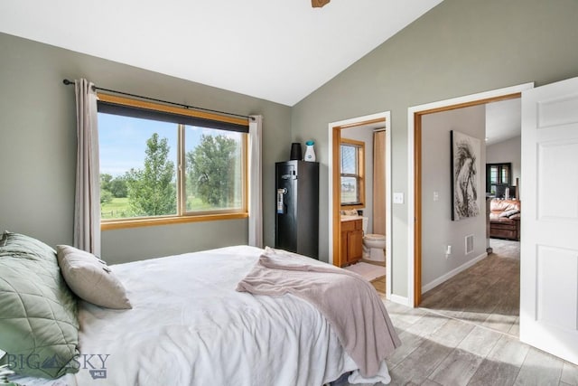 740 Linda Ln, Three Forks, MT 59752 - bedroom featuring vaulted ceiling, light wood-type flooring, and connected bathroom
