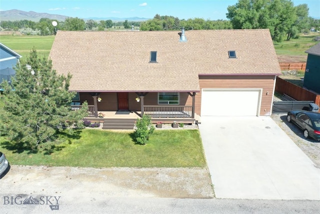740 Linda Ln, Three Forks, MT 59752 - view of front of property featuring a shingled roof, covered porch, driveway, a mountain view, and an attached garage