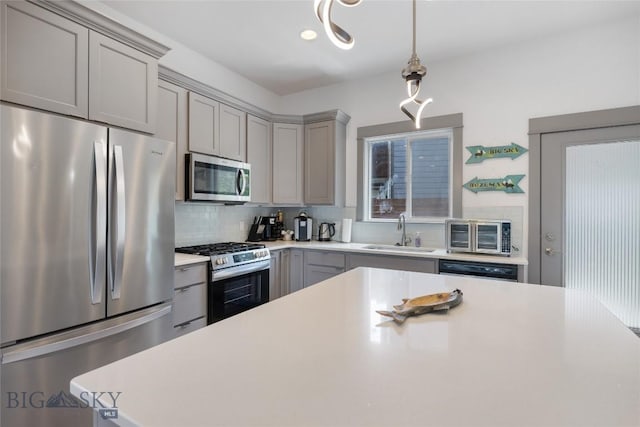 26 Locomotive Loop, Bozeman, MT 59718 - kitchen featuring stainless steel appliances, gray cabinets, backsplash, and light countertops