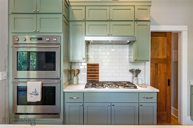 425 S Yellowstone St, Livingston, MT 59047 - kitchen with green cabinetry, appliances with stainless steel finishes, light countertops, and decorative backsplash