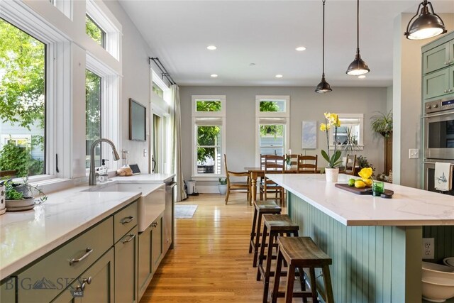 425 S Yellowstone St, Livingston, MT 59047 - kitchen featuring light wood-style flooring, double oven, recessed lighting, a breakfast bar area, and hanging light fixtures