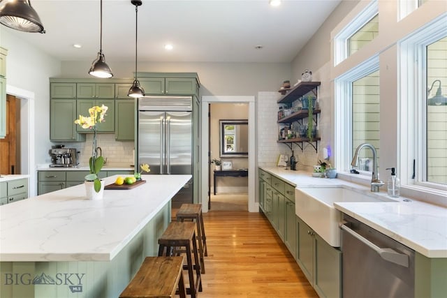 425 S Yellowstone St, Livingston, MT 59047 - kitchen featuring green cabinetry, appliances with stainless steel finishes, decorative backsplash, open shelves, and light wood-type flooring