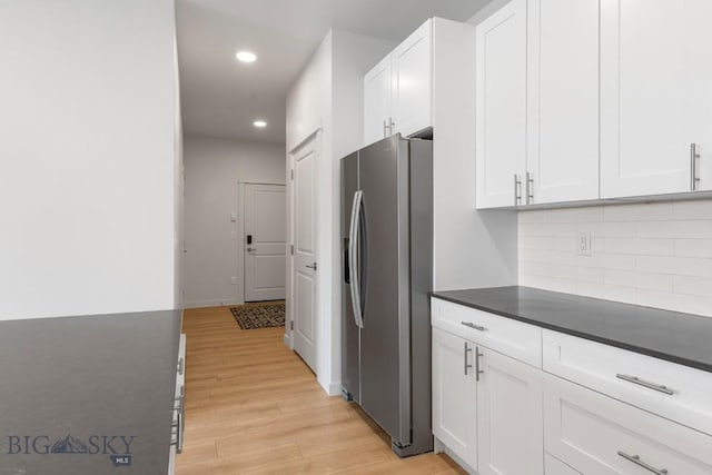 2221F Willow Unit 104, Livingston, MT 59047 - kitchen with stainless steel fridge, dark countertops, light wood-type flooring, white cabinetry, and recessed lighting