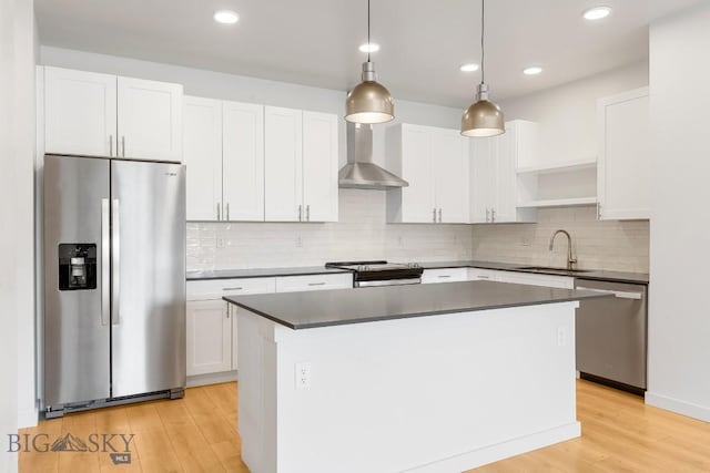 2221F Willow Unit 104, Livingston, MT 59047 - kitchen with appliances with stainless steel finishes, light wood-style floors, a center island, white cabinets, and dark countertops