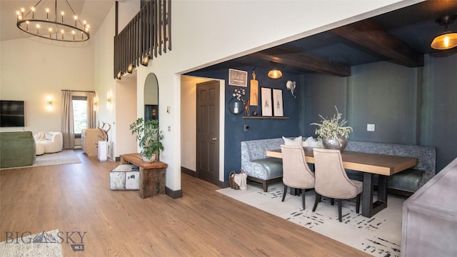 3640 Jagar Ln, Bozeman, MT 59718 - dining space with wood finished floors, a chandelier, beam ceiling, and a high ceiling