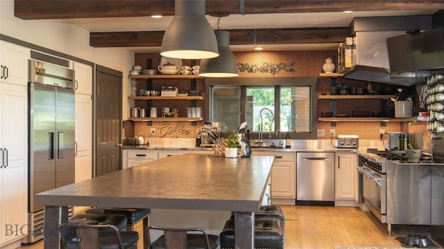 3640 Jagar Ln, Bozeman, MT 59718 - kitchen featuring stainless steel countertops, appliances with stainless steel finishes, open shelves, and beamed ceiling