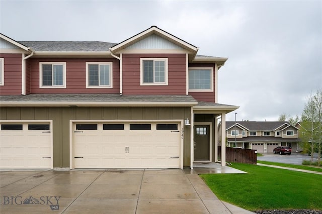 2740 Cobblestone Unit A, Bozeman, MT 59718 - townhome / multi-family property with board and batten siding, a garage, driveway, a shingled roof, and a front lawn