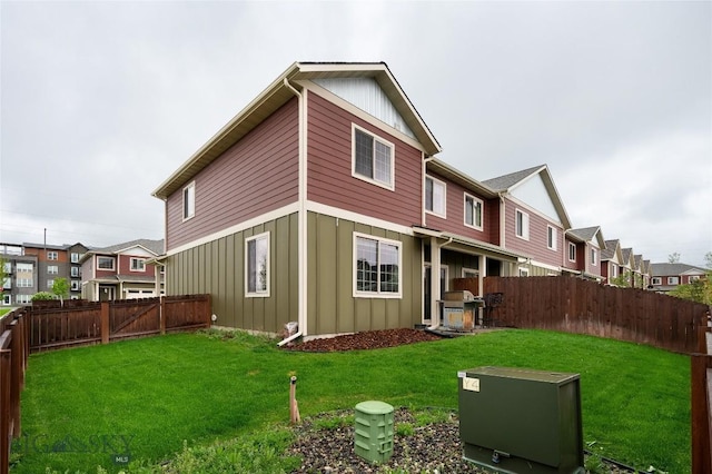 2740 Cobblestone Unit A, Bozeman, MT 59718 - back of house featuring board and batten siding, a fenced backyard, and a residential view