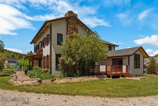 250 Silver Run Rd, Gallatin Gateway, MT 59730 - back of house with a chimney, a wooden deck, a lawn, and a storage shed