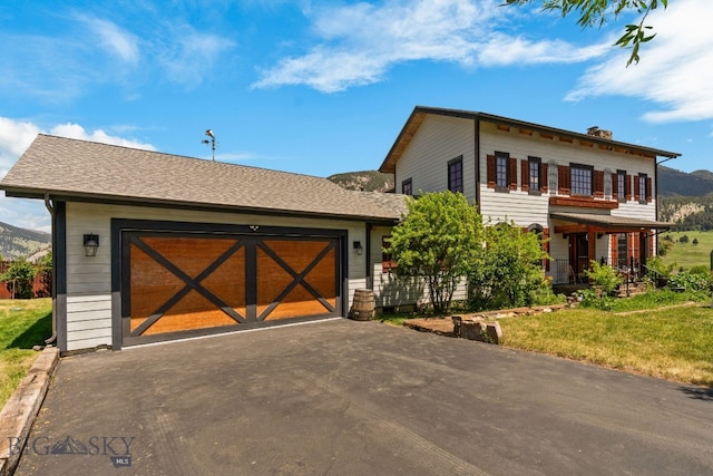 250 Silver Run Rd, Gallatin Gateway, MT 59730 - view of front of home with asphalt driveway, a garage, a front yard, a mountain view, and a chimney
