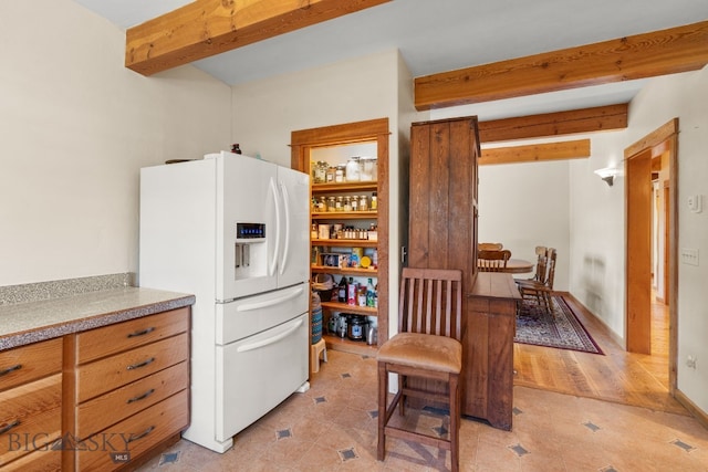 250 Silver Run Rd, Gallatin Gateway, MT 59730 - kitchen featuring white fridge with ice dispenser, beamed ceiling, light tile patterned floors, and light countertops