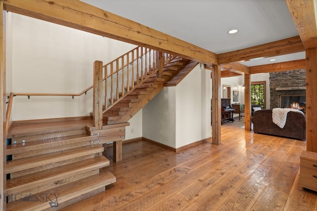 250 Silver Run Rd, Gallatin Gateway, MT 59730 - stairs with hardwood / wood-style floors, recessed lighting, beamed ceiling, and a fireplace