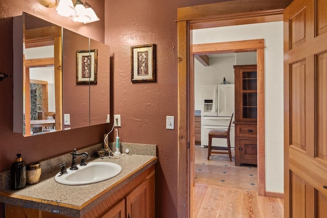 250 Silver Run Rd, Gallatin Gateway, MT 59730 - bathroom with a textured wall, vanity, wood finished floors, and a chandelier