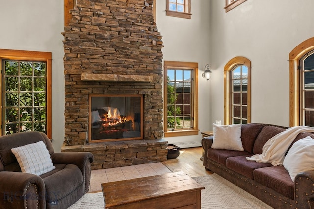 250 Silver Run Rd, Gallatin Gateway, MT 59730 - living area with a towering ceiling, a fireplace, wood finished floors, and baseboard heating