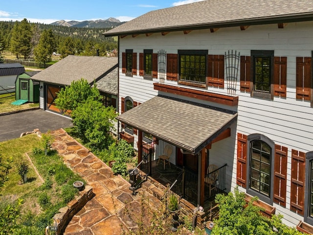 250 Silver Run Rd, Gallatin Gateway, MT 59730 - view of home's exterior with a shingled roof, a mountain view, and a garage